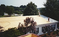 applying base coat on foam roof